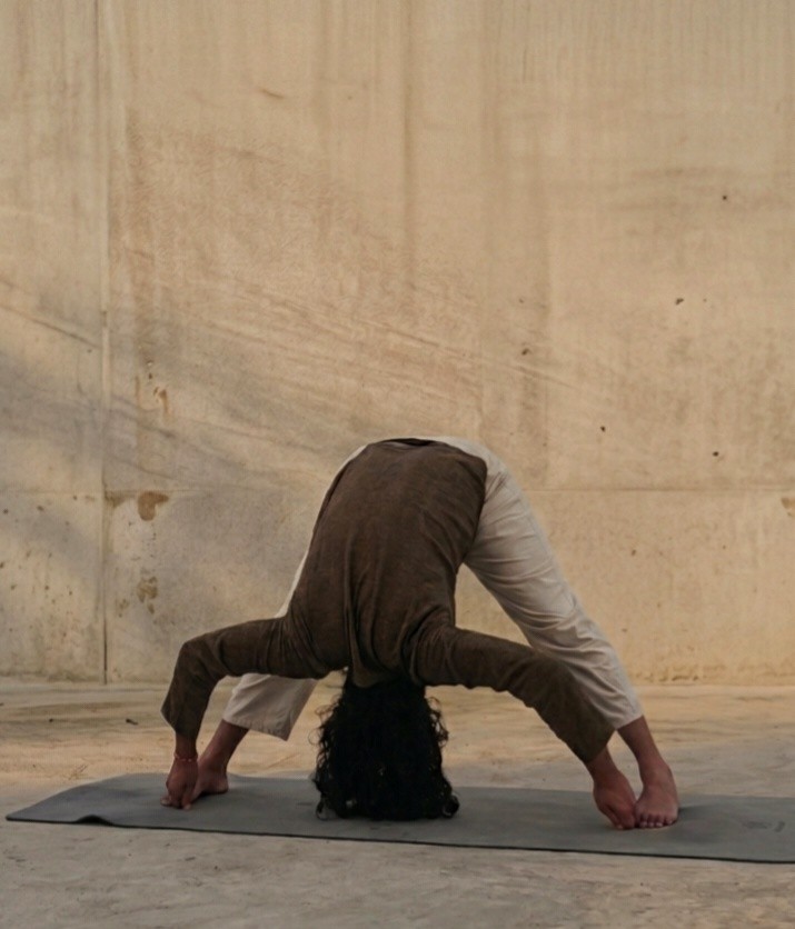 Forward fold practice against a raw concrete wall